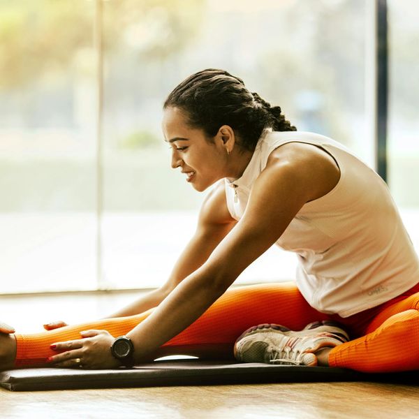 Smiling woman stretching outdoors, feeling vibrant and full of energy.